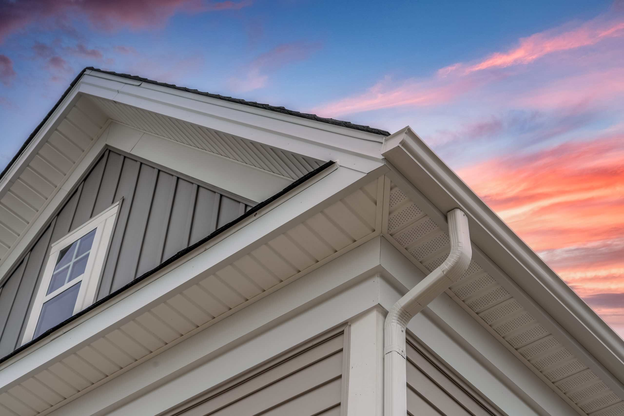 White frame gutter guard system, with gray horizontal and vertic Modern Okanagan home with dark corrugated metal panel and wood-accent siding installed by Hi-Lite Exteriors